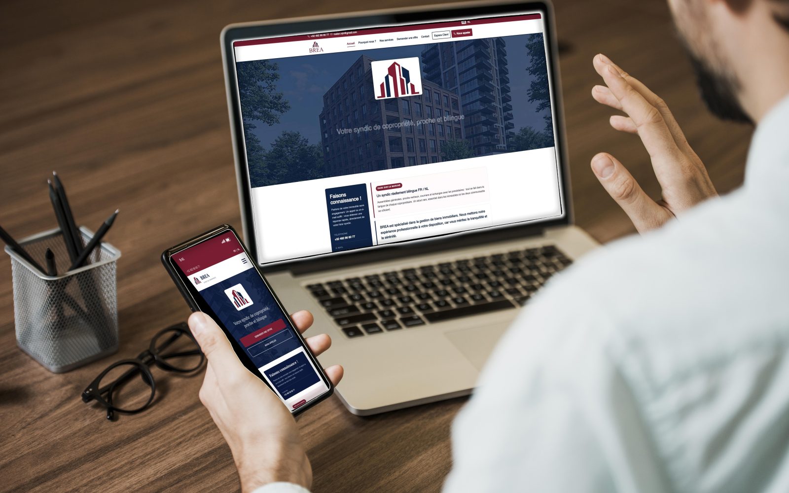 Le site de BREA ouvert au même moment sur un ordinateur portable et sur un téléphone, posés sur un bureau en bois : la version bureau montre la page d'accueil complète, la version mobile la même page réorganisée en une colonne.