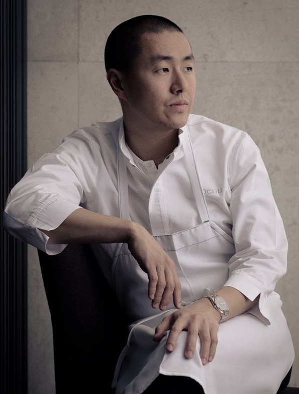 Portrait du chef Tanaka assis, en veste blanche