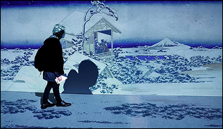 A visitor in front of a digital projection of a snowy Hokusai landscape